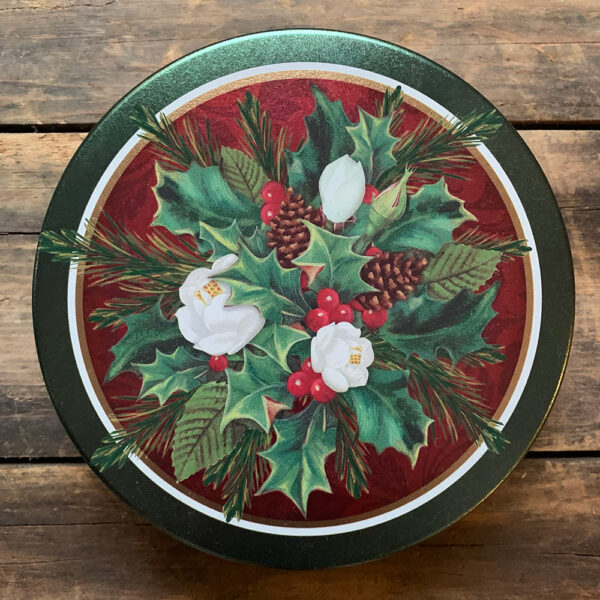 Red and green tin with an image of a Christmas bouquet of holly, fir and pinecones